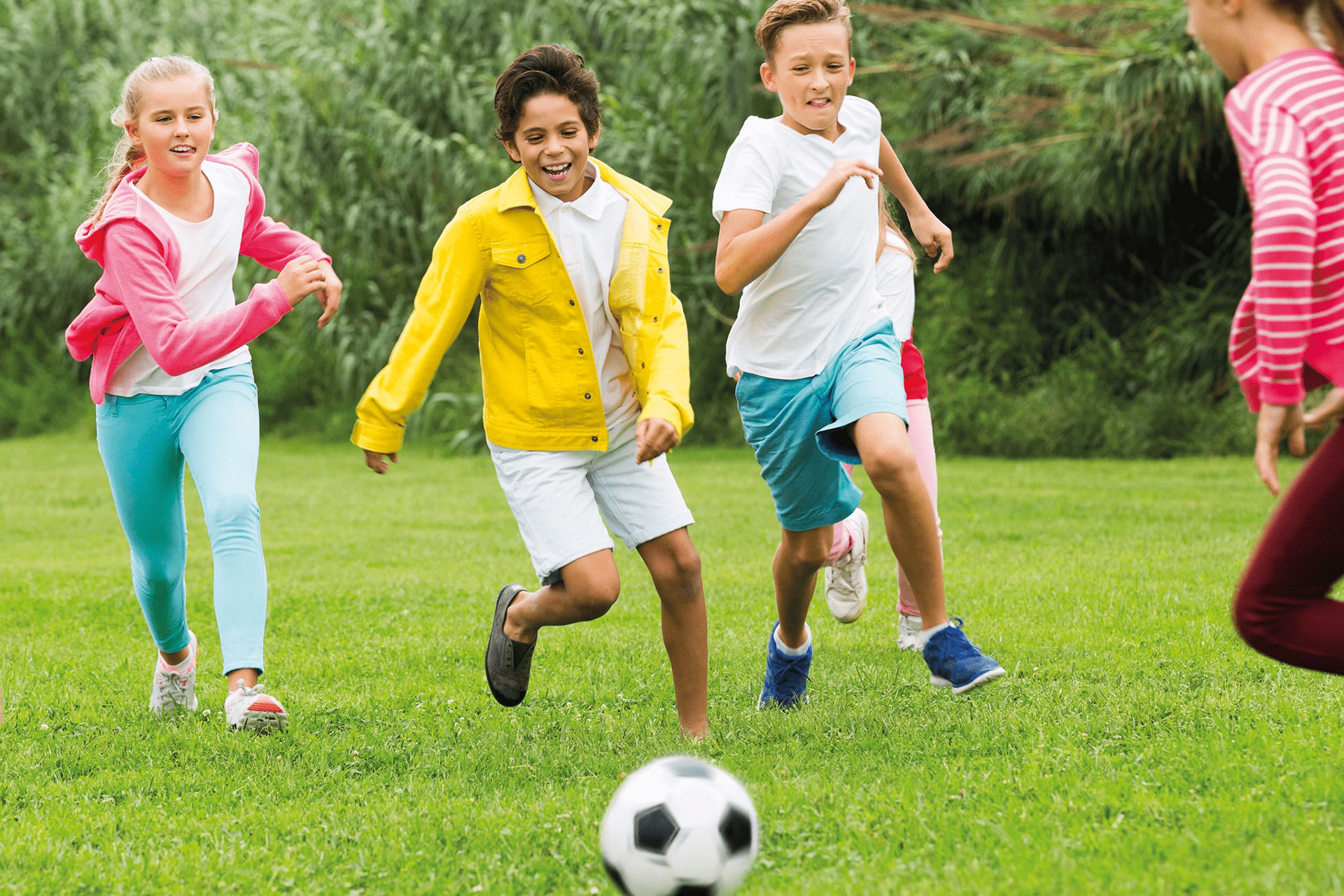 They play football well. Play Football in the Park. They are playing Soccer. Children playing on the grass. Kids having fun Фотобанк Лори.